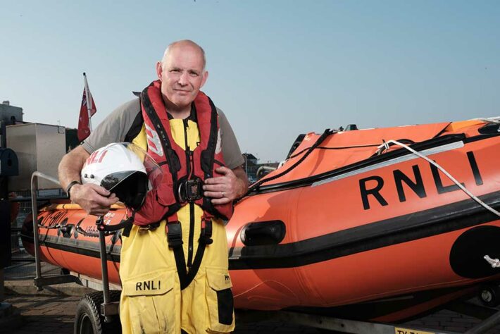 Keith next to an RNLI boat ready for launch telling his diabetic foot ulcer story