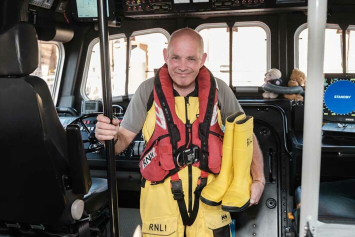 Keith with his wellies onboard an RNLI boat